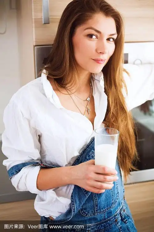 一个年轻漂亮的女人,手里拿着一杯牛奶