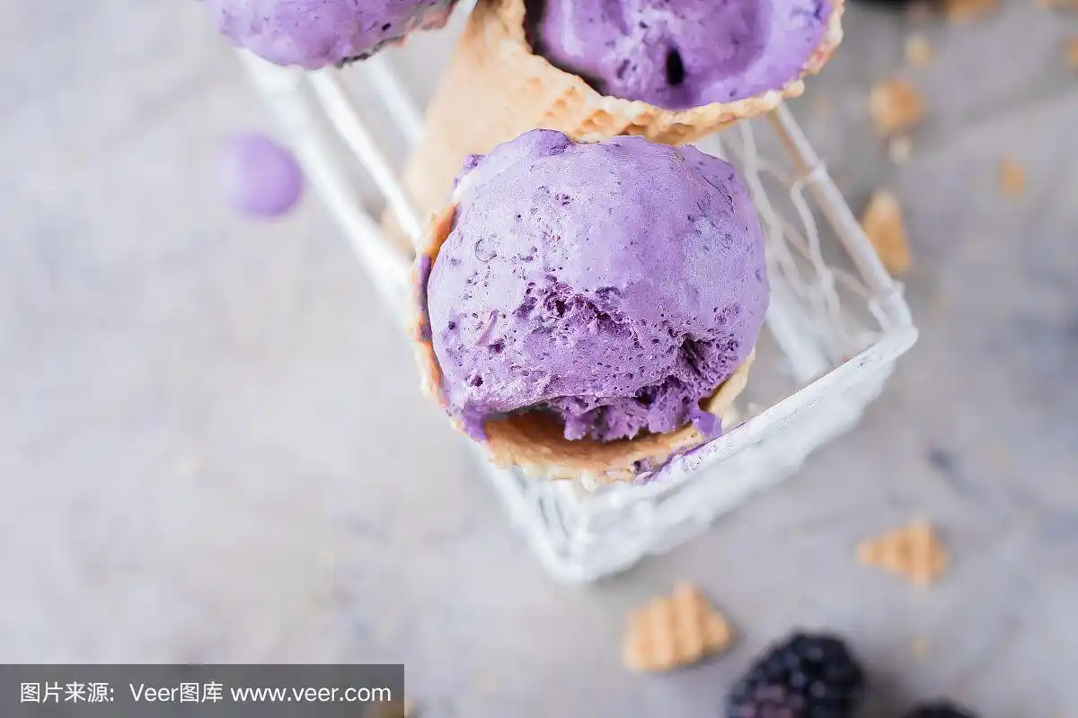 美味的浆果黑莓紫色冰淇淋在灰色的石头桌子的背景.夏天美味的甜点.
