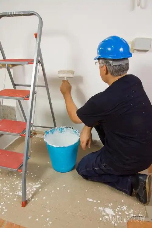 工人油漆刷在墙上