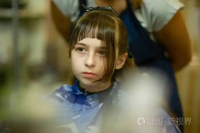 理发师给可爱的小女孩做发型