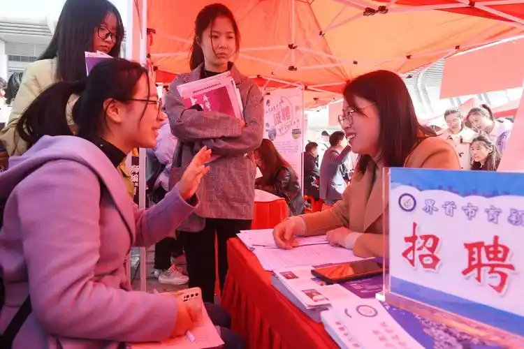 安徽省阜阳市,求职大学生正在双选招聘会现场了解招聘信息.王彪 摄