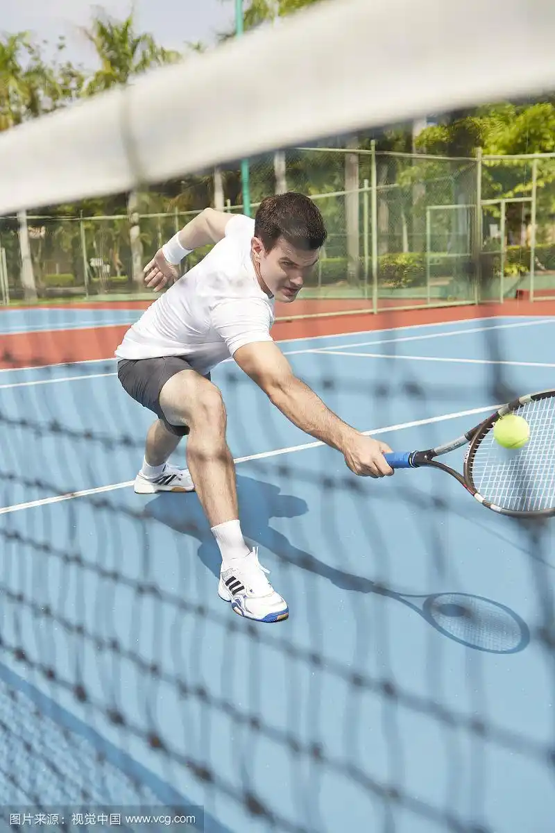 男子穿着运动服打网球的照片