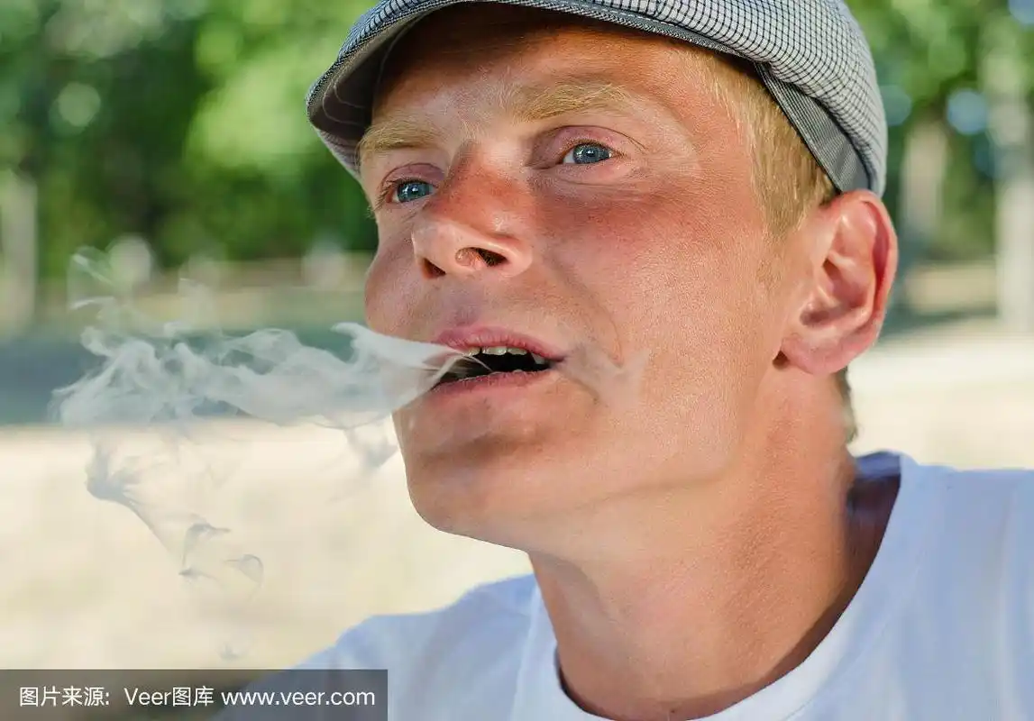 从嘴里吐出烟的男人