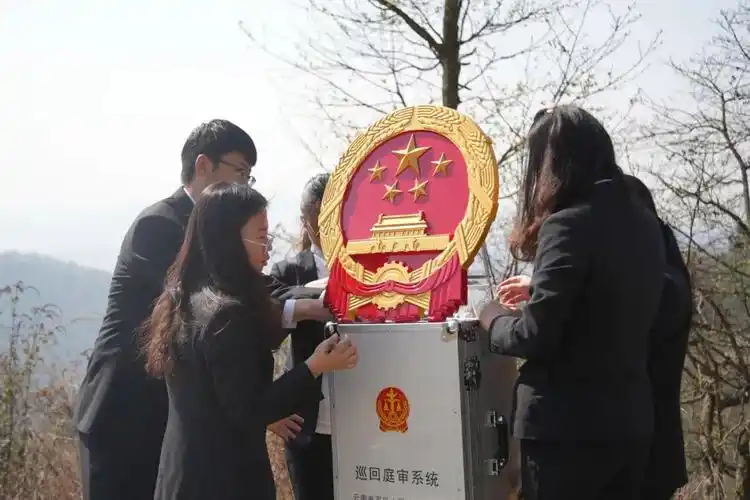 挂上国徽,在桌上摆好"调解员""原告""被告"等牌子,一个临时的简易法庭