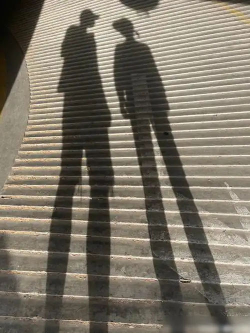 照片中二人的腿的影子被拉得很长,成为了两双超级大长腿,搭配着层层的