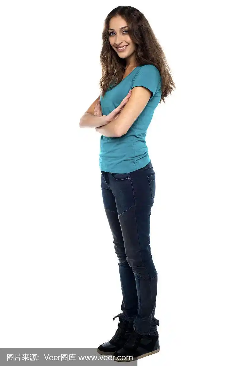 双臂交叉,侧身站着的时髦女人