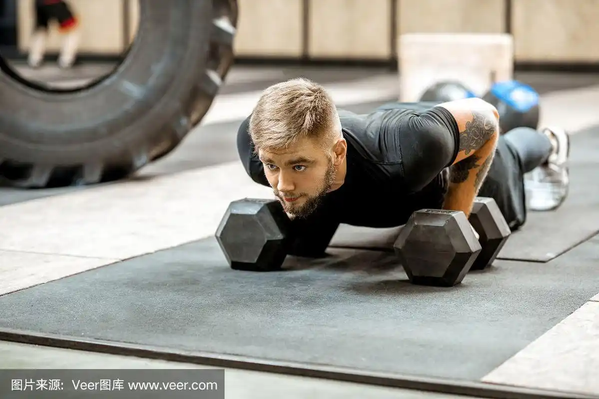 在健身房里做俯卧撑的男人