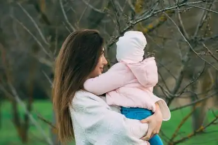 母亲带着女儿在沙滩上玩耍.母亲抱着女儿照片