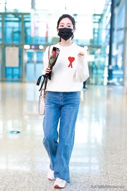 祝绪丹白色毛衣搭牛仔裤现身机场手拿鲜花心情好