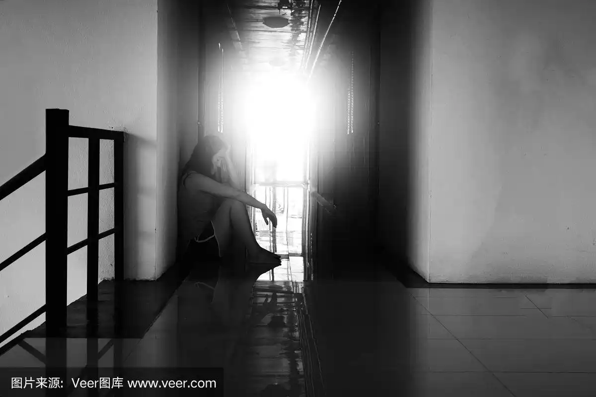 绝望的女人坐在黑暗的走廊里