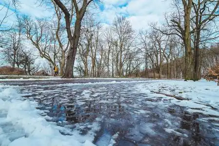 融化的雪. 路上的水坑. 城市公园. 春天来了照片