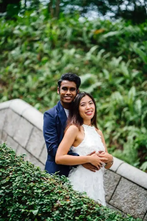 在亚洲, 一个有吸引力的情侣在公园里站在一起.他们正在拍婚礼照片.