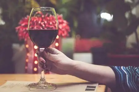 一个女孩手里拿着一杯红酒, 调子.概念女孩和酒精照片