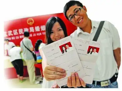 一对幸福的新人在晒他们刚刚领到的结婚证. 资料照片