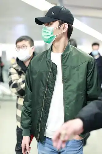 组图:王凯穿绿色飞行夹克现身机场 赶路不时低头看手机