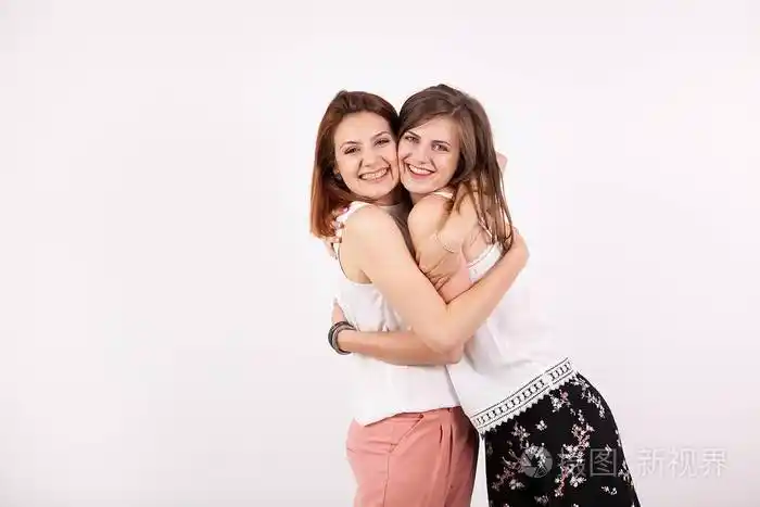 两个美丽的女孩朋友拥抱对方