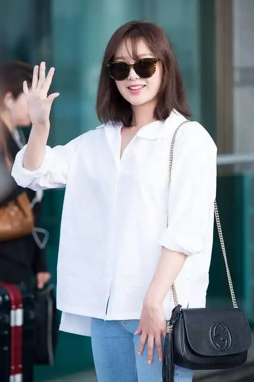 这张照片中的金智媛是一头利落的短发,戴着精致的耳饰,上身选择一个