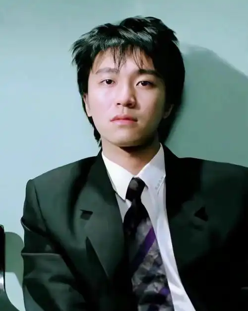 照片中,周星驰身穿白色短袖,头戴一顶帽子,状态看起来很好,蹲在地上用