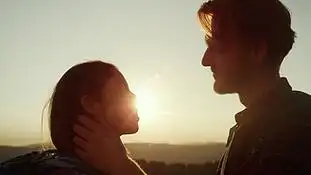 深情的男人看着女人的眼睛站在山顶上的情侣