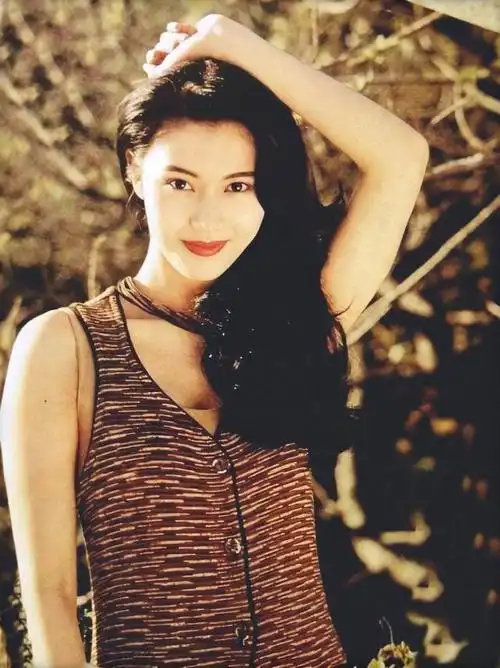 年轻时的李嘉欣美丽大方,身着紫色吊带长裙,温柔浪漫