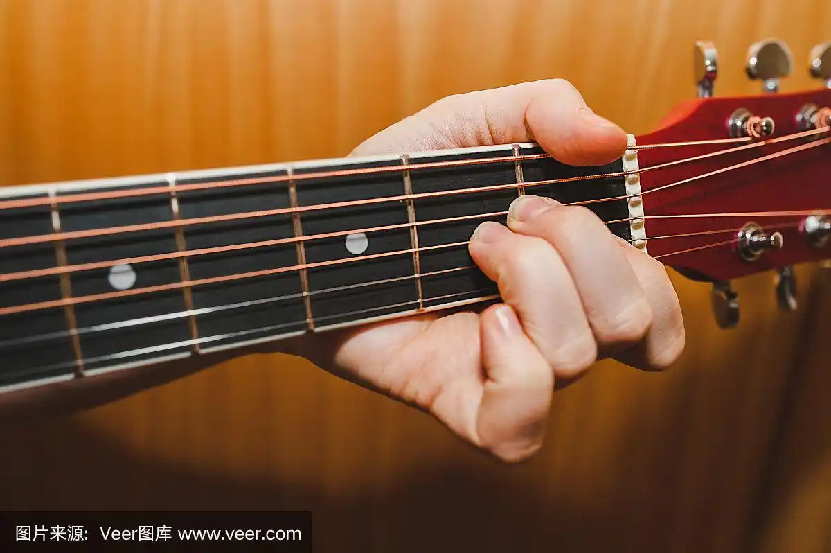 浅色皮肤的手握着一个六弦吉他的am和弦.学弹吉他,生活特写
