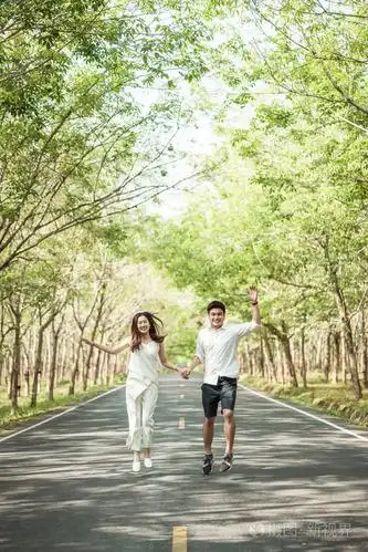 幸福的亚洲情侣在树拱门的路上相爱