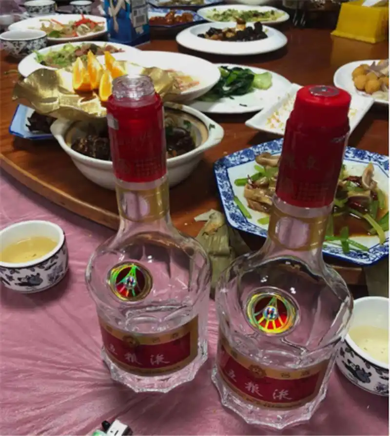 在外婆的寿宴上,餐桌上除了有丰盛的菜肴外,也有中国好酒五粮液.