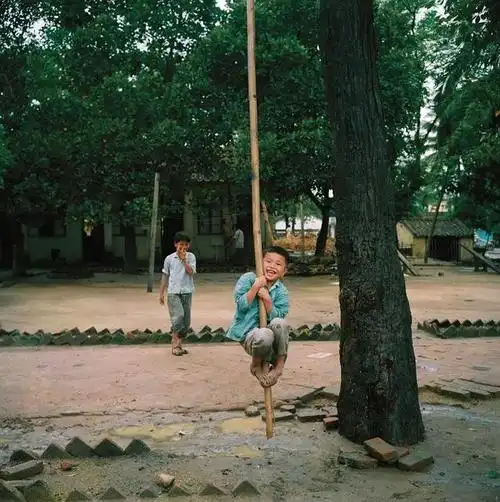 海口,一位正在爬竹竿的小男孩.