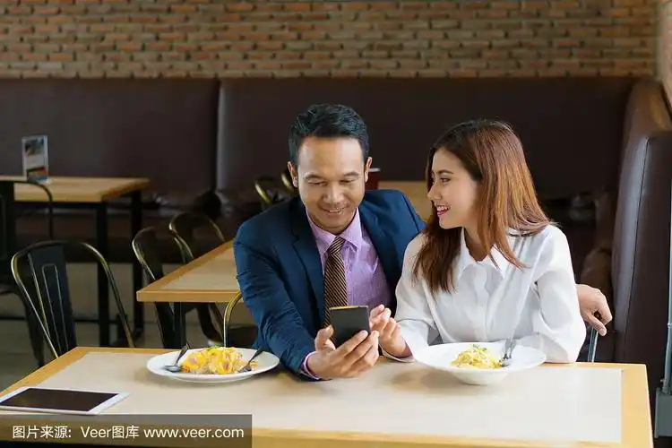 情人在餐厅,商业情侣在餐厅一起吃饭.