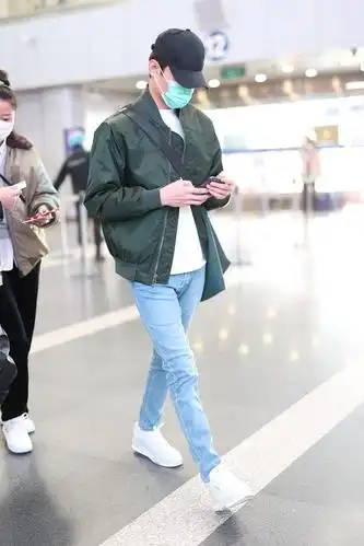 组图:王凯穿绿色飞行夹克现身机场 赶路不时低头看手机