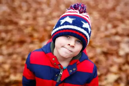 有趣的孩子在秋天森林或公园的乐趣在寒冷的天.冬季童装休闲时尚照片