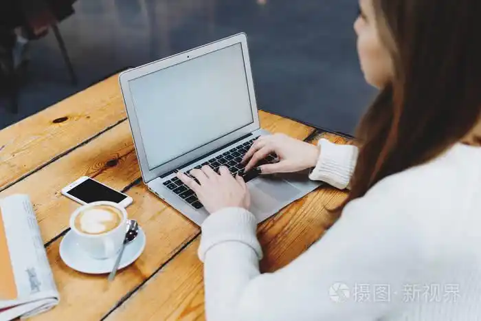 白人女性坐在开放式笔记本电脑前, 空着空白屏幕