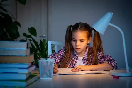 晚上女孩做作业,在家学习.照片