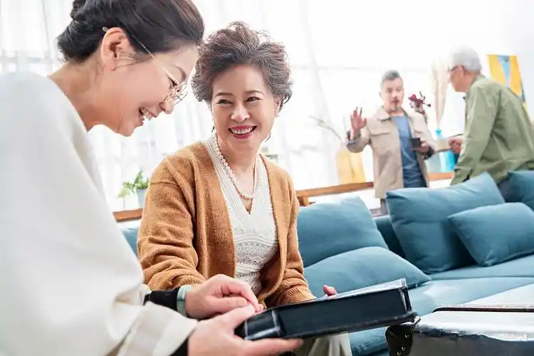 退休的中老年人在室内聊天看相册叙旧