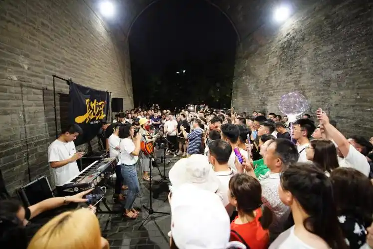 游客在西安城墙南门下观看一支乐队表演(7月3日摄).