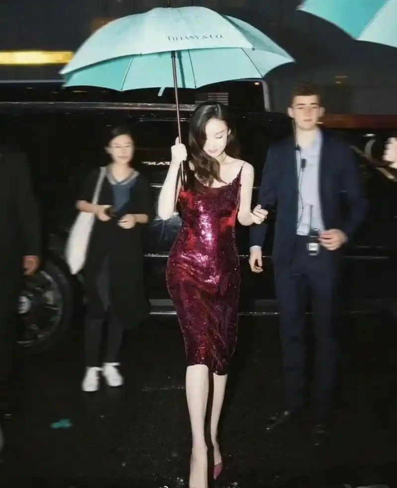 倪妮打伞的照片,无论是氛围还是取景,还有她的肢体语言以及整个照片的