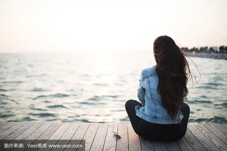 年轻女子坐着看日落