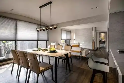 客餐厅通铺深木色木地板,素白地毯上摆了l型米白色