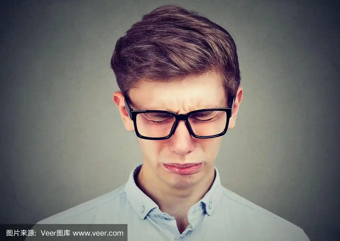 一个戴着眼镜哭泣的少年男子的特写