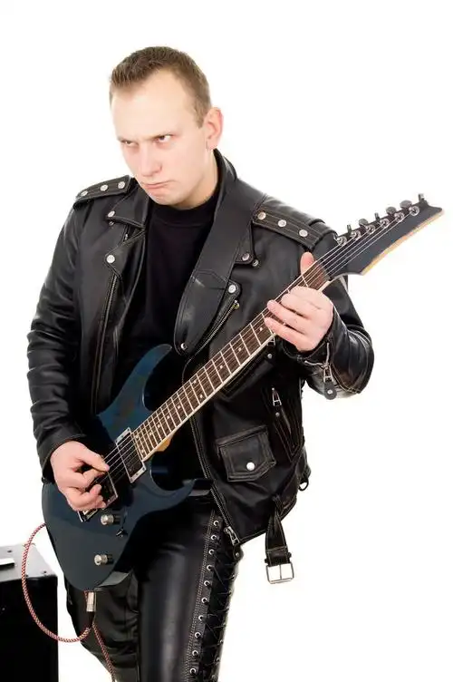 摇滚吉他手在皮革服装,与声音放大设备