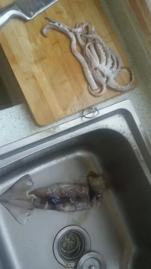 把鱿鱼须从头部分离下来.分解完毕,去黑膜!