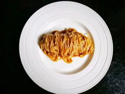 把鞭得焦黄的小葱和大蒜撒在面条上,再淋上少许生抽做装饰,最后再撒上