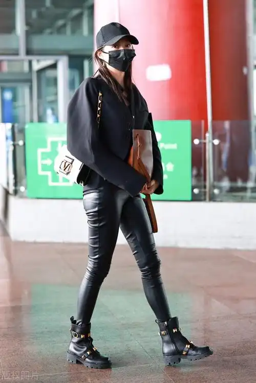 关晓彤穿黑色短外套搭配黑色皮裤脚踩黑色短靴戴棒球帽帅气十足