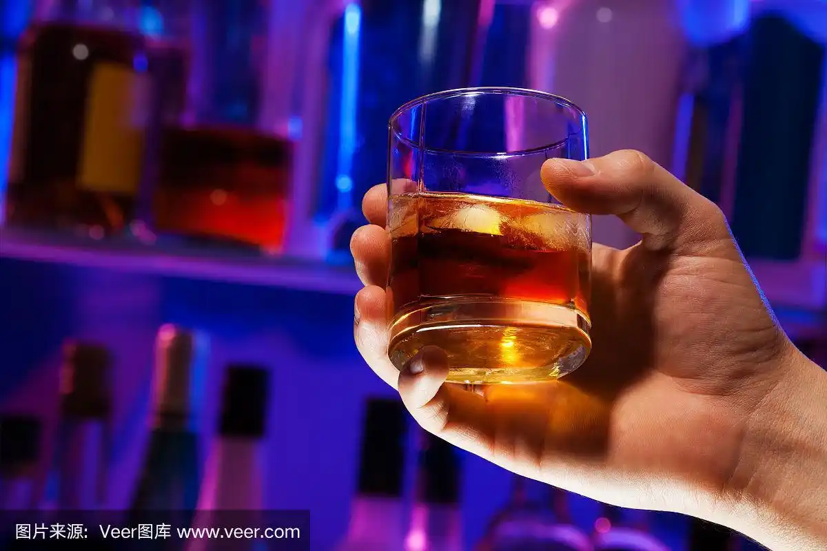 男人在酒吧拿着威士忌酒杯