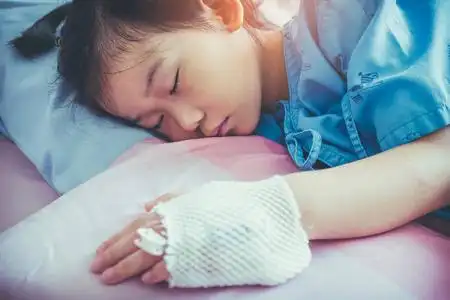 疾病亚洲孩子手上送往医院与生理盐水静脉注射 (iv)照片