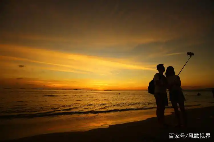 1月18日,一情侣在三亚湾美丽夕阳中游玩,自拍.