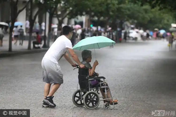 哈尔滨大雨突袭 男子雨中为老人撑伞获称赞