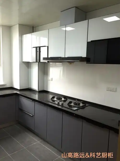 地柜为深灰色玻璃门板陪黑色石英石台面,吊柜采用白色玻璃门板减轻了