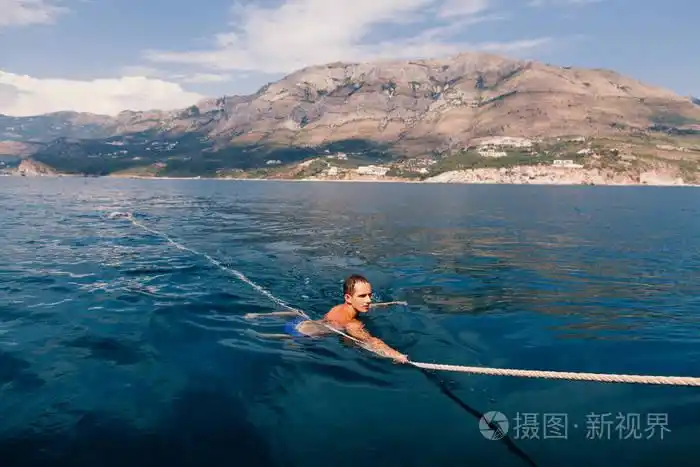 英俊的男人在大海里游泳