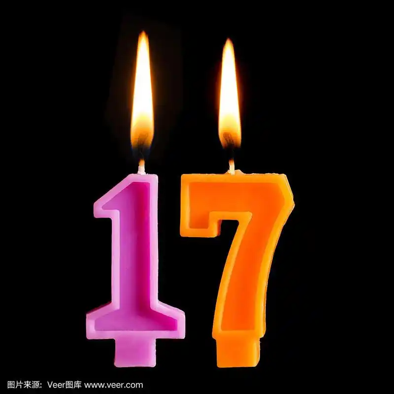 燃烧的生日蜡烛在17 17数字的形式为蛋糕孤立在黑色的背景.